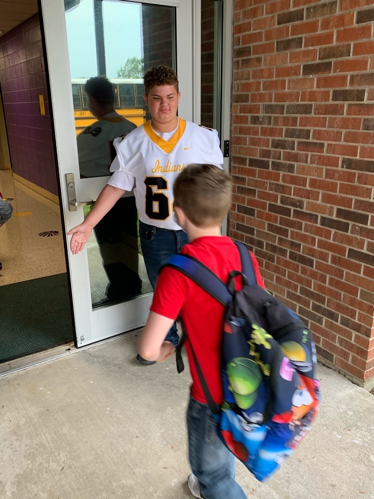 football player greets students 